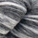 A close-up of gray and white striped fuzzy yarn or fiber texture filling the frame.