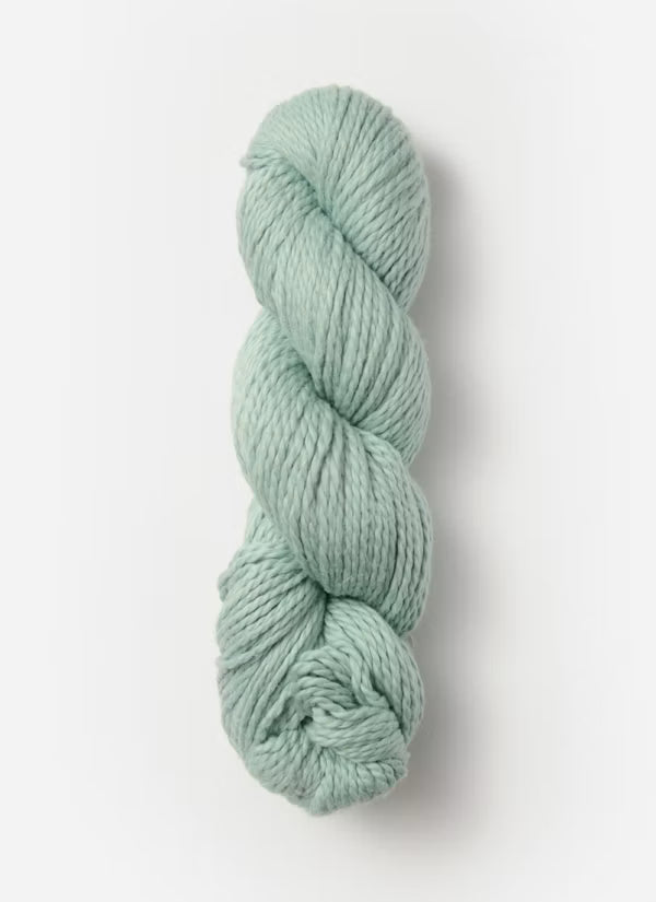 Skein of light green yarn on a white background