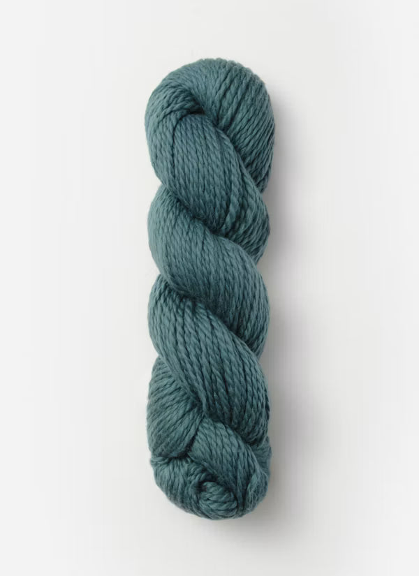 A single skein of twisted yarn in a muted teal blue-green color, photographed vertically against a clean white background.