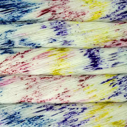 A close-up of a textured fabric or wallpaper pattern featuring horizontal white stripes with colorful paint splatters in red, blue, yellow, and purple.