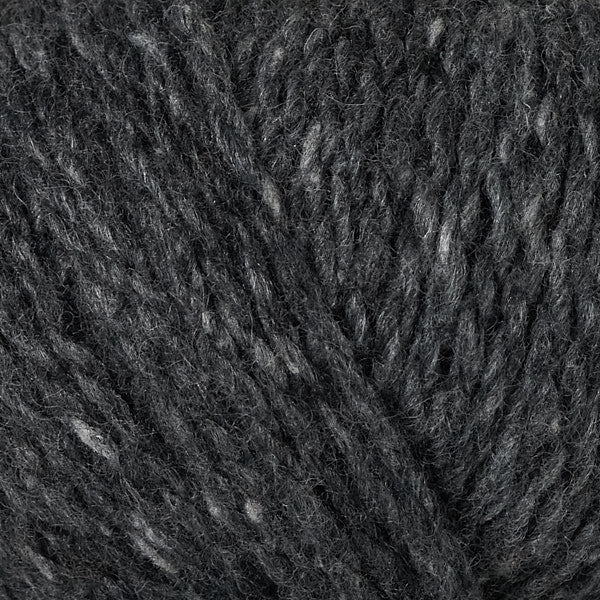 A close-up texture shot of dark charcoal gray yarn with subtle lighter gray and white flecks throughout.