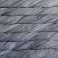 A close-up texture shot of thick gray plied yarn or thread, filling the entire frame.