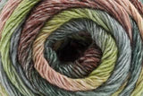 A close-up of a wound skein of variegated yarn showing multiple colors including olive green, mustard yellow, peach, and dark brown in a spiral pattern.