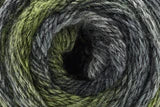 A close-up of a textured yarn ball or skein showing a variegated color pattern of olive green, black, and gray.