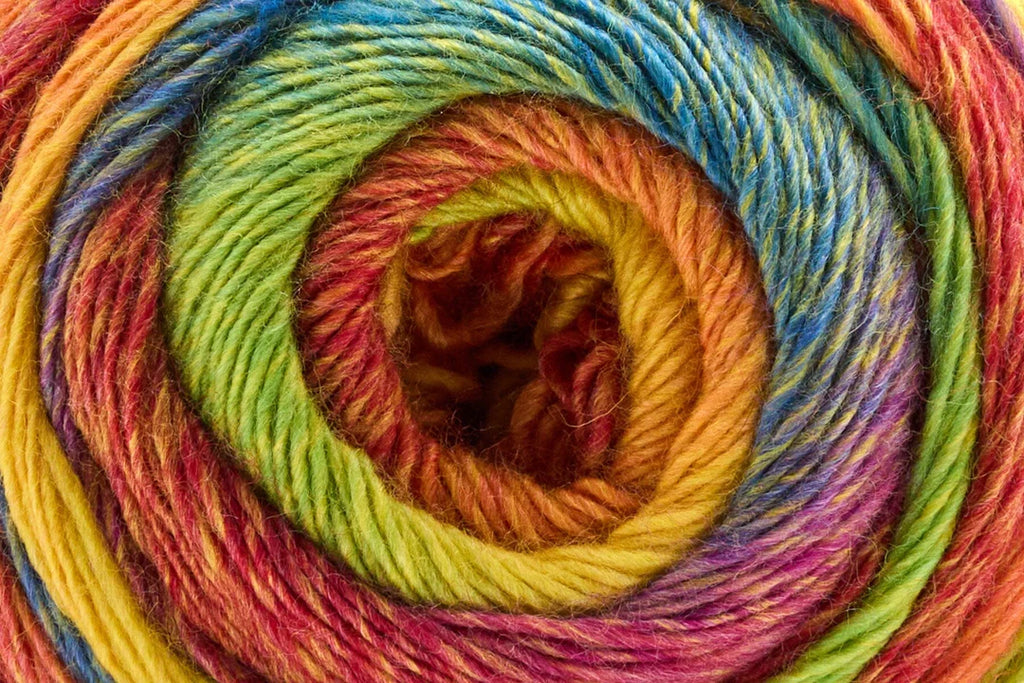 A close-up of a variegated yarn skein wound in a spiral pattern, showing multiple colors including yellow, green, blue, pink, and orange.