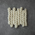 Set of braided white ropes on a gray surface