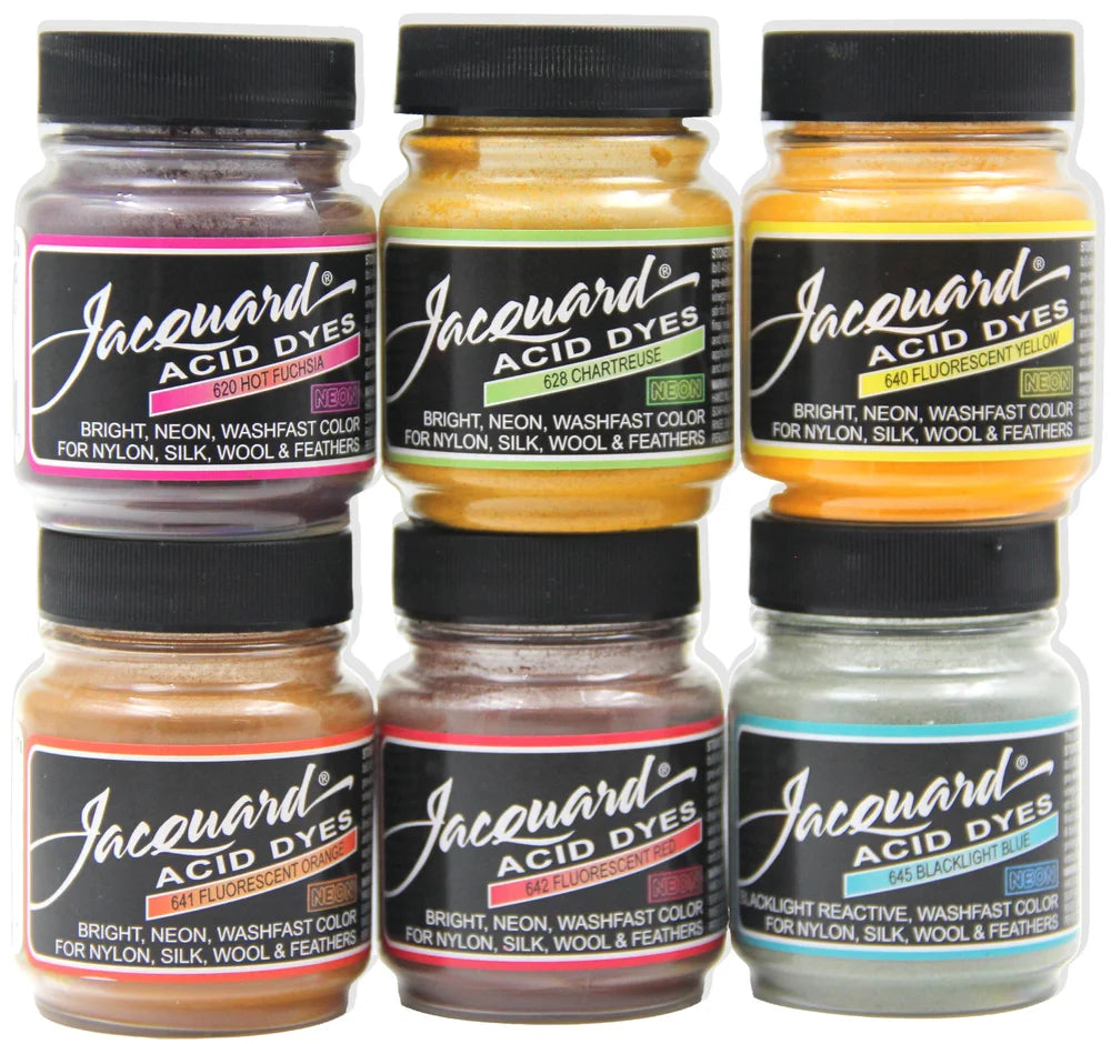 Six jars of Jacquard Acid Dyes arranged in two rows of three on a plain white background. The jars contain various colored dyes including purple, yellow, orange, brown, red, and blue, each with a black cap and a black label featuring the brand name.