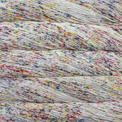 Close-up of a skein of variegated yarn with white/off-white base and dense multicolored flecks in red, blue, yellow, and purple.