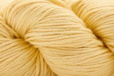 A close-up of a pale buttery yellow skein of yarn, showing the twisted plies and soft texture.