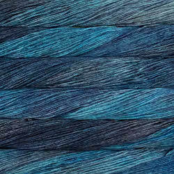 A close-up of textured yarn strands layered horizontally, showing a color gradient from bright teal blue to deep navy and charcoal gray.