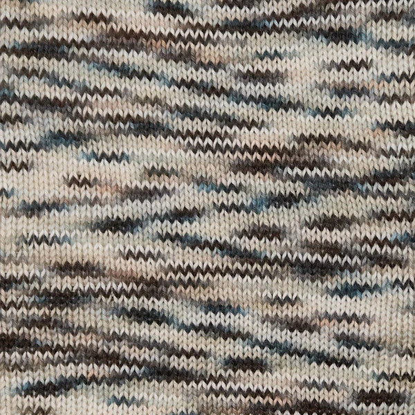 Close-up of a knitted fabric with a variegated pattern of beige, brown, black, and muted blue-gray yarns.