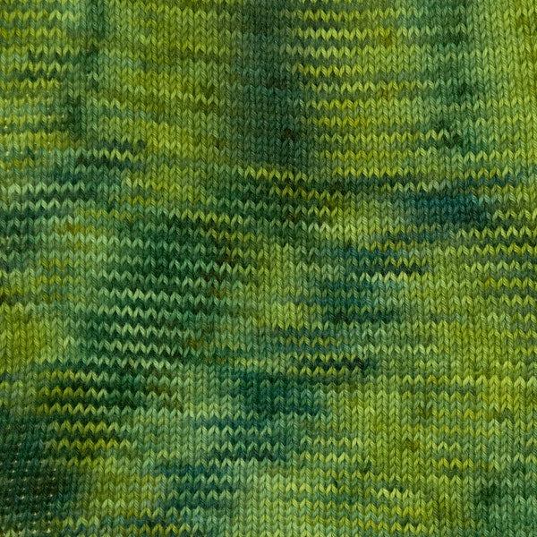 Close-up of a knitted fabric with a variegated pattern of olive green, forest green, and yellow-green yarns.