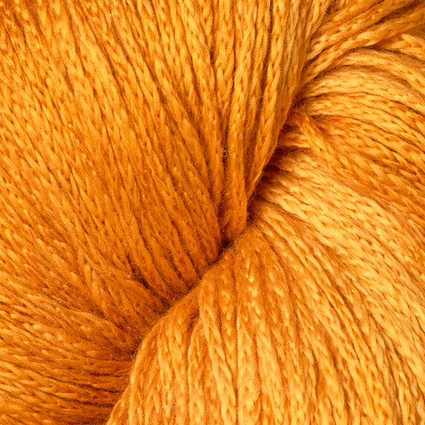 A close-up of twisted yarn in a warm golden orange color, showing the texture of the fibers.