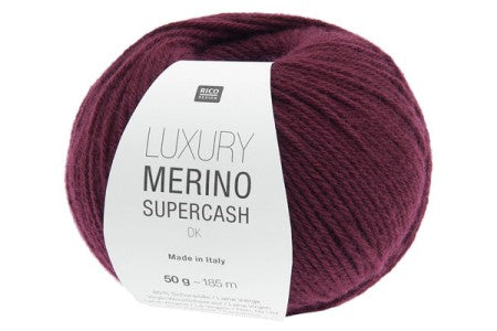 A ball of BICO Merino Supercash yarn in a deep burgundy color, featuring a white paper label with black text, set against a plain white background.
