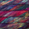 Close-up of colorful yarn strands wound into skeins, showing a multicolor blend of purple, pink, teal, blue, yellow, and red tones.