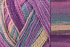 Close-up of variegated yarn with alternating stripes of purple, pink, blue, green, and beige, alongside a knitted fabric swatch showing the same colorway.