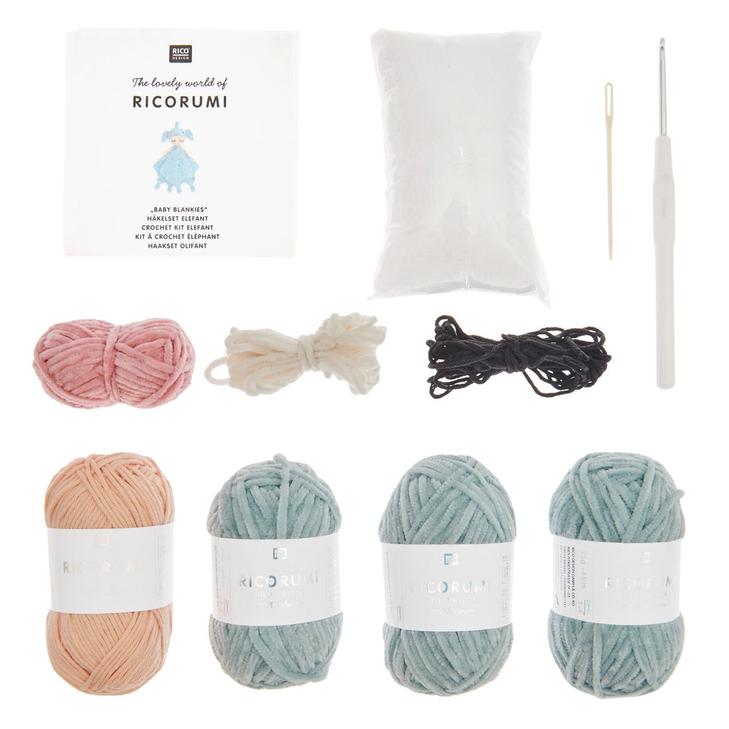 Crochet kit with yarn, a pillow, and a crochet hook on a white background