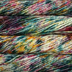 Close-up of variegated yarn strands in a marled multicolor pattern with teal, pink, yellow, orange, and cream tones.