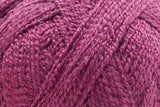 A close-up of textured yarn in a dusty magenta-purple color, showing the soft plied structure of the fiber.