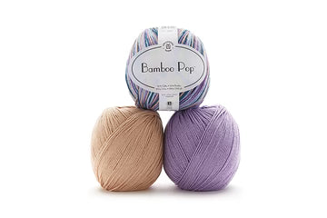 Three balls of Bamboo Pop yarn stacked in a pyramid on a white background, featuring pastel purple, lavender, and light beige colors.