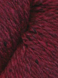 A close-up of dark burgundy wool yarn with subtle black flecks, showing the soft texture and twisted plies of the fiber.