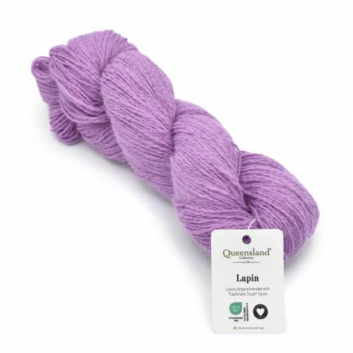 A skein of lavender purple yarn with a white product tag that reads 'Queensland Yarns Lapin' on a plain white background.