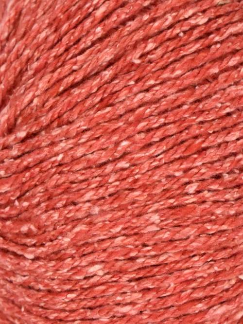Close-up of twisted yarn fibers in a warm coral-red or terracotta tone, filling the entire frame.