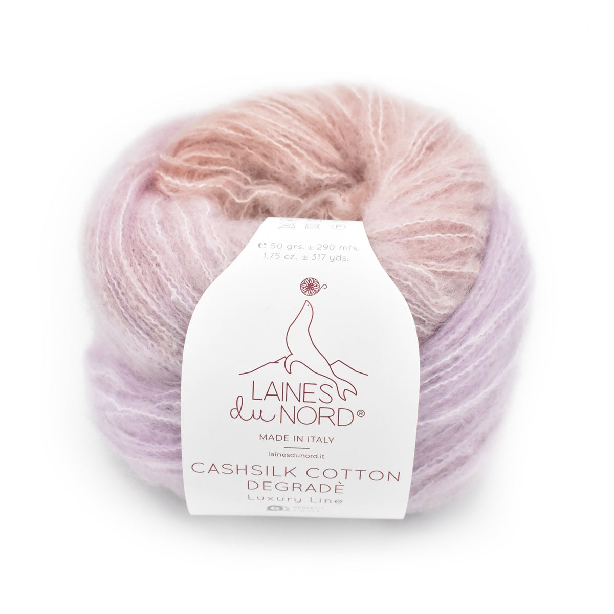 A skein of Laines du Nord Cashsilk Cotton Degrade luxury yarn in a soft pastel blend of pink and lavender, with a white paper label wrapped around it, on a plain white background.