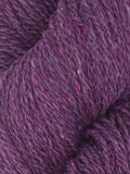 Close-up of purple yarn with speckles, showing texture and color.
