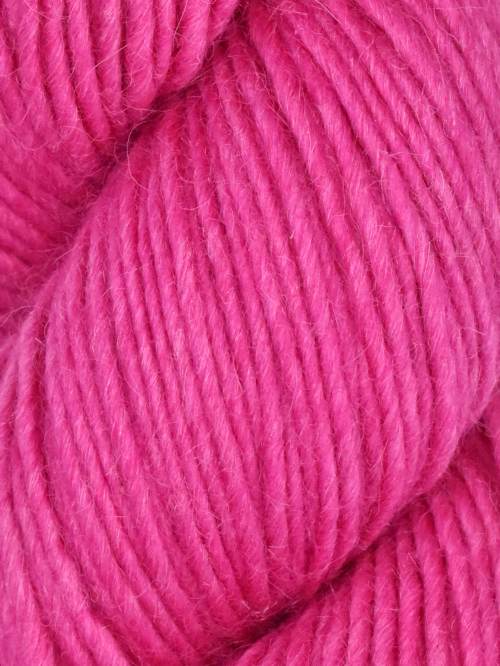 A close-up of bright pink yarn with a soft, fuzzy texture filling the frame.