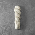 Coiled skein of yarn on a textured gray background