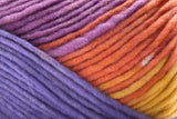 Close-up of a variegated yarn skein showing a smooth color transition from purple and lavender to orange, yellow, and light peach.