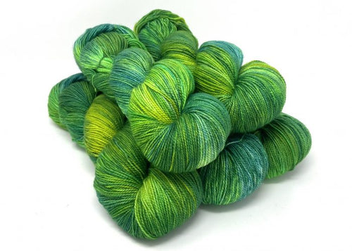 Green and blue skeins of yarn on a white background