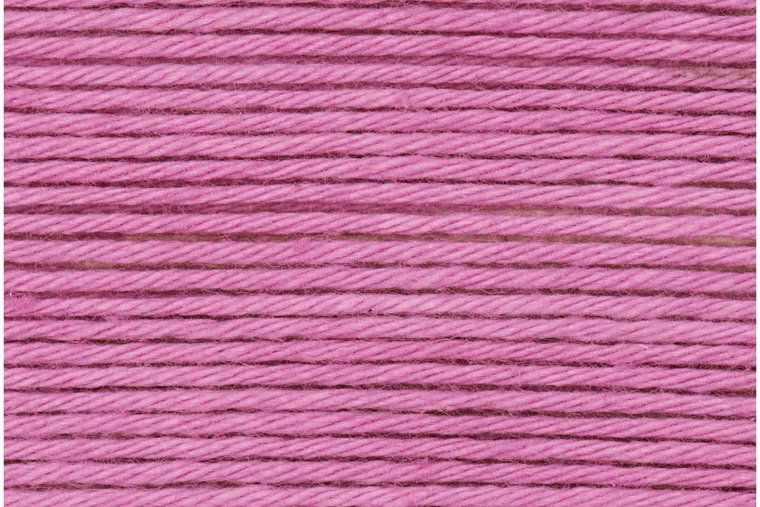 A close-up texture shot of bright pink embroidery thread wound horizontally.