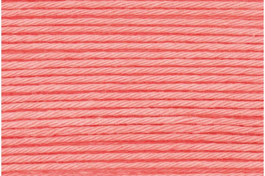 A close-up texture shot of coral pink embroidery thread wound horizontally.