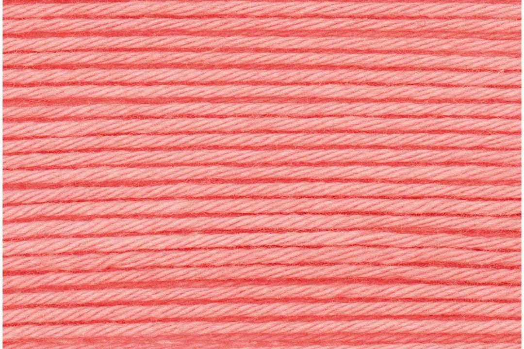 A close-up texture shot of coral pink embroidery thread wound horizontally.
