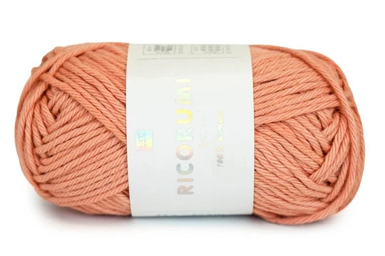 Ball of pink yarn with a label on a white background