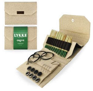 Lykke Grove handcrafted wooden spoons in a natural linen storage case, shown open alongside its green and beige packaging box on a white background.