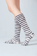 Striped socks worn by a person on a light gray background