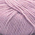 A close-up of dusty pink yarn wound into a skein, showing the soft, twisted texture of the fibers.
