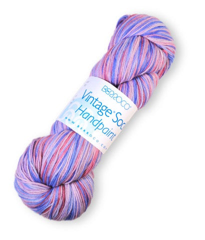 A skein of variegated yarn with pink, purple, and blue stripes, wrapped with a white paper label that reads 'Bianco Co Vintage Soft Handpainted'.