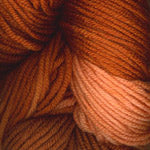Close-up of variegated yarn in warm orange, rust, and peach tones.