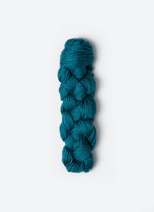 Braided teal yarn on a white background