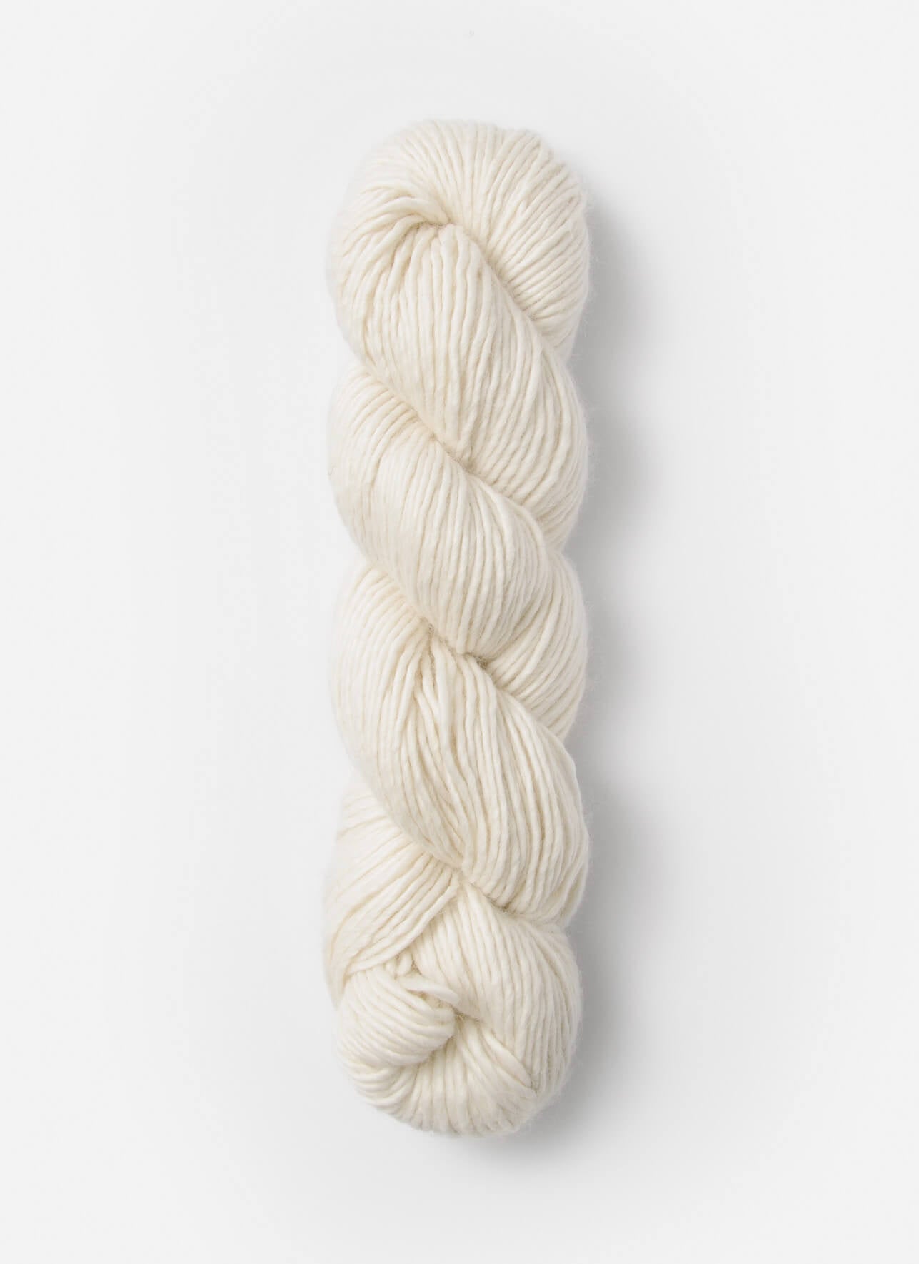 A single skein of cream-colored yarn standing vertically against a clean, light off-white background.