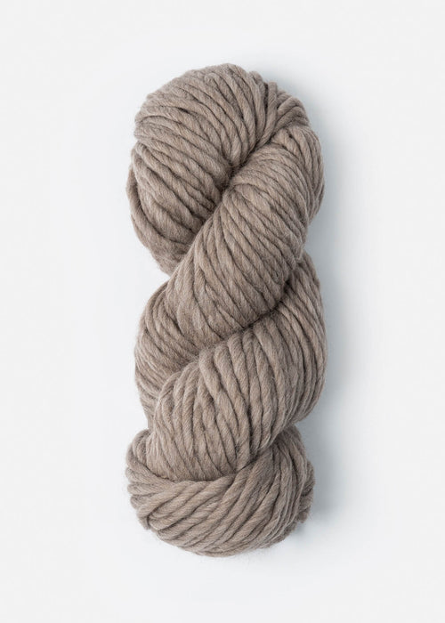 Coiled skein of beige yarn on a white background