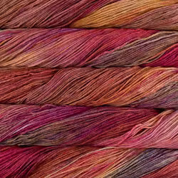 Close-up of variegated yarn strands stacked horizontally, showing a blend of warm and cool tones including pink, red, orange, purple, and gray.