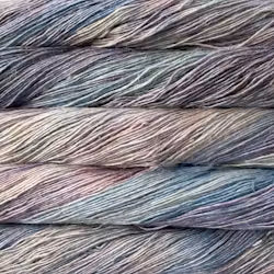 Close-up of twisted yarn strands stacked horizontally, showing a variegated color mix of dusty blue, lavender, mauve, and gray.