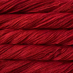 A close-up of deep red yarn wound into horizontal skeins, showing the texture and color of the fiber.
