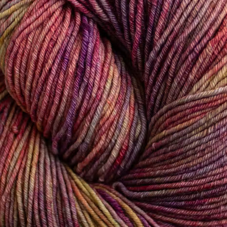 A close-up of variegated yarn with blended shades of purple, pink, red, beige, and olive green, showing the texture of the twisted plies.
