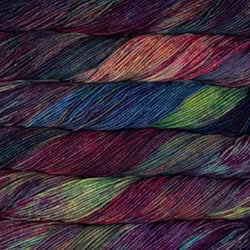 Multicolored yarn skeins stacked on a dark background